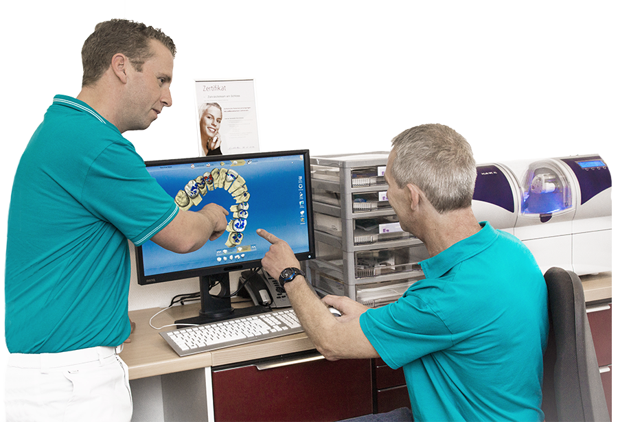 Zahnlabor Zahnarzt Dr. Borgmann bespricht mit dem Zahntechnikermeister im Labor das Zahnbild, das auf dem Computerbildschirm dargestellt wird.